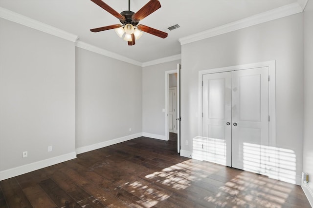 unfurnished bedroom with a closet, crown molding, baseboards, and wood-type flooring