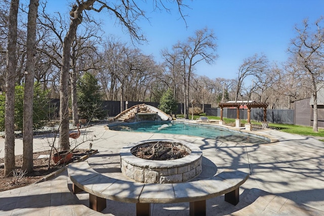 view of swimming pool with a patio area, a fenced backyard, a pergola, and a water slide