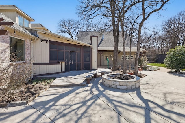 view of patio featuring a sunroom and an outdoor fire pit