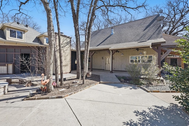 view of front of house with a patio, a ceiling fan, and a shingled roof