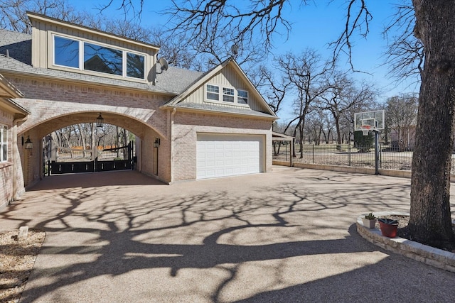 view of property exterior with fence, brick siding, driveway, and a shingled roof