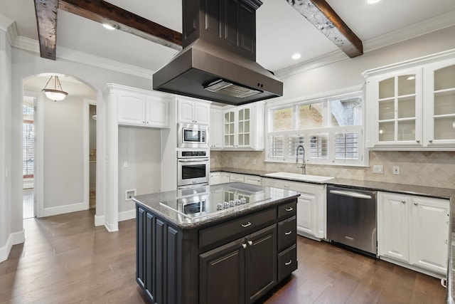 kitchen with arched walkways, a sink, extractor fan, appliances with stainless steel finishes, and white cabinetry