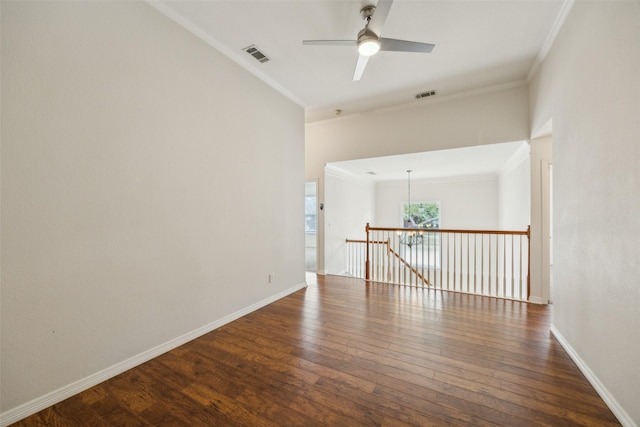 empty room with visible vents, crown molding, and dark wood-type flooring