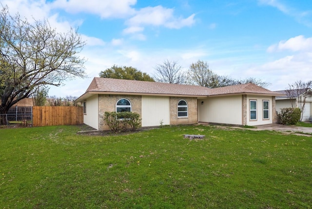 single story home featuring brick siding, a front yard, and fence