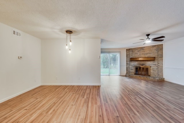 unfurnished living room featuring a ceiling fan, wood finished floors, visible vents, baseboards, and a fireplace