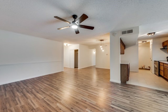 unfurnished living room with visible vents, baseboards, ceiling fan, light wood-type flooring, and a textured ceiling