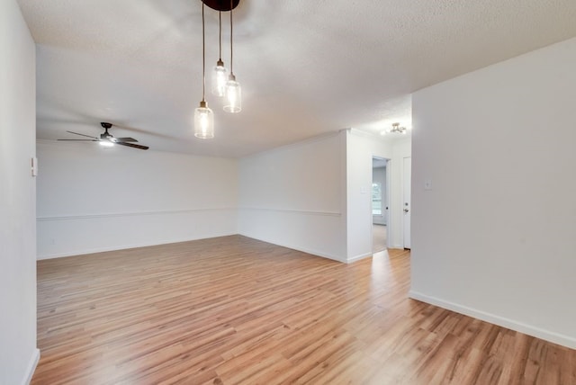 unfurnished room featuring ceiling fan, light wood-style floors, baseboards, and a textured ceiling