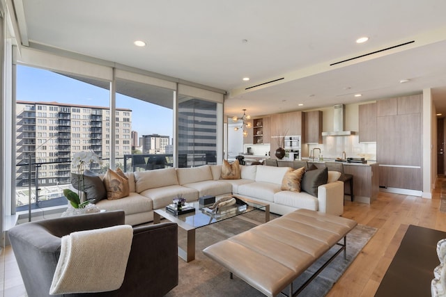 living room featuring recessed lighting, light wood-type flooring, and a city view