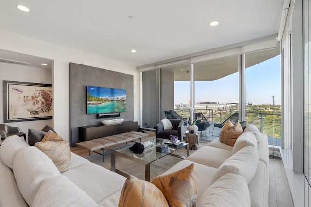 living area featuring recessed lighting, expansive windows, and wood finished floors