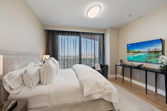 bedroom featuring baseboards and wood finished floors