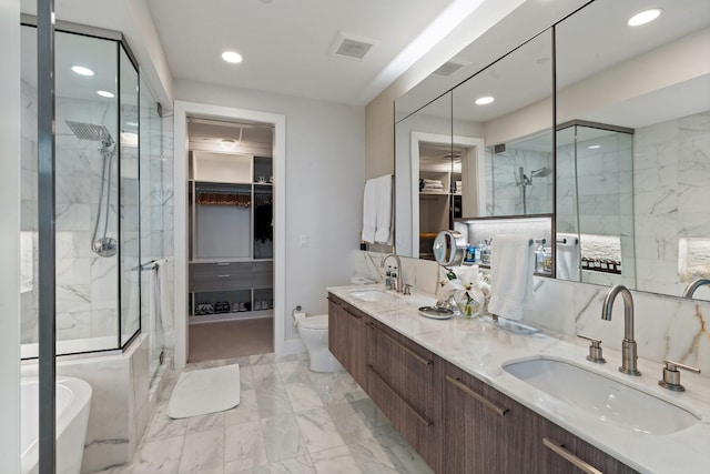 bathroom featuring a sink, a marble finish shower, marble finish floor, and a spacious closet