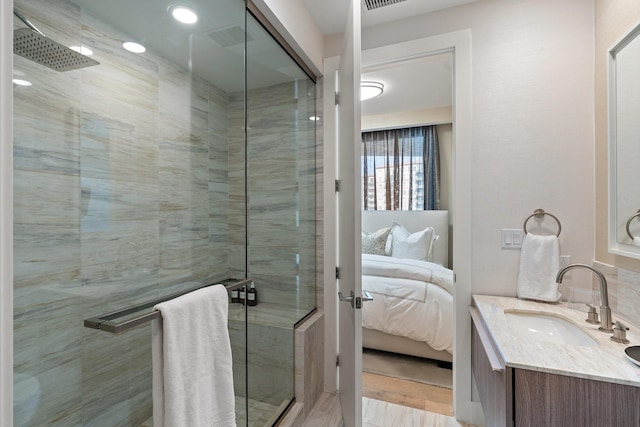 full bath with a shower stall, ensuite bath, vanity, and wood finished floors