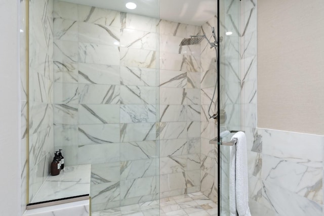 bathroom featuring a marble finish shower