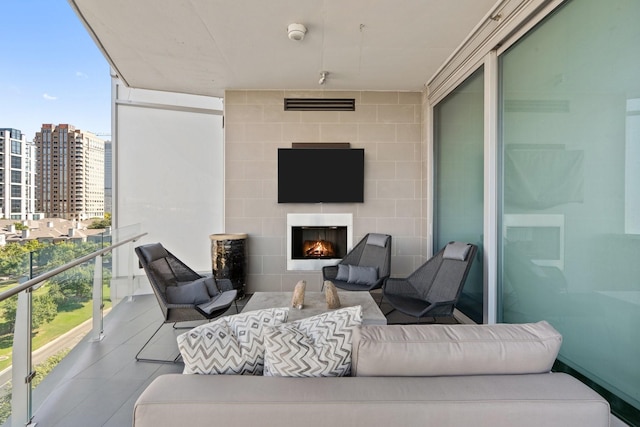 balcony featuring an outdoor living space with a fireplace and a view of city