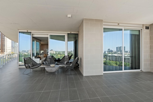 view of patio with a balcony and a city view