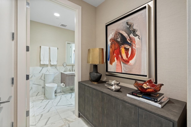 interior space with visible vents, marble finish floor, toilet, and vanity