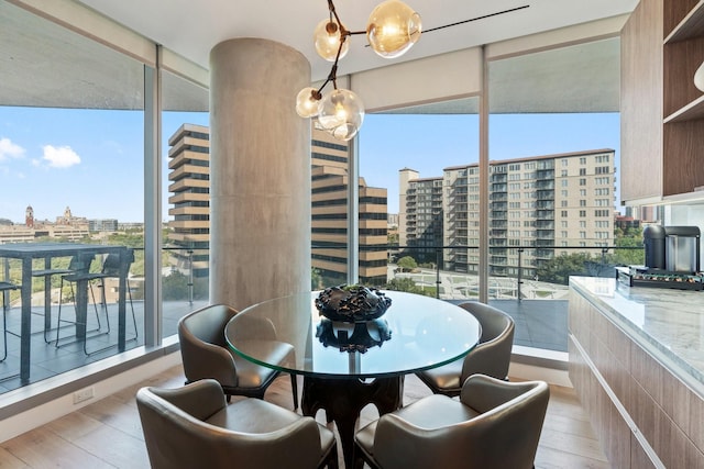 dining room with a wall of windows, a city view, and wood finished floors