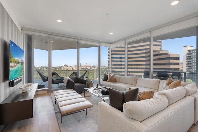 living room with recessed lighting, expansive windows, a city view, and wood finished floors