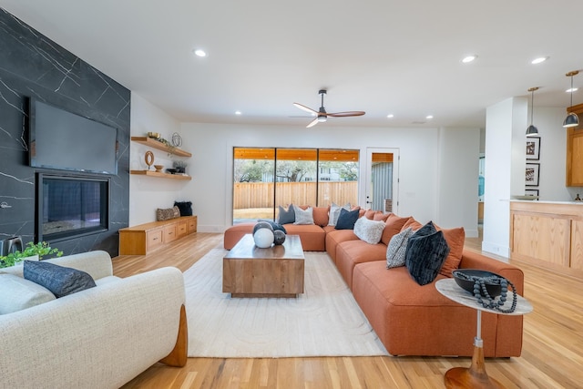 living room featuring recessed lighting, a fireplace, a ceiling fan, and wood finished floors