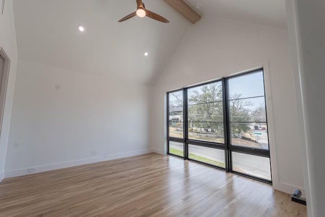 spare room featuring beam ceiling, high vaulted ceiling, light wood-style floors, baseboards, and ceiling fan