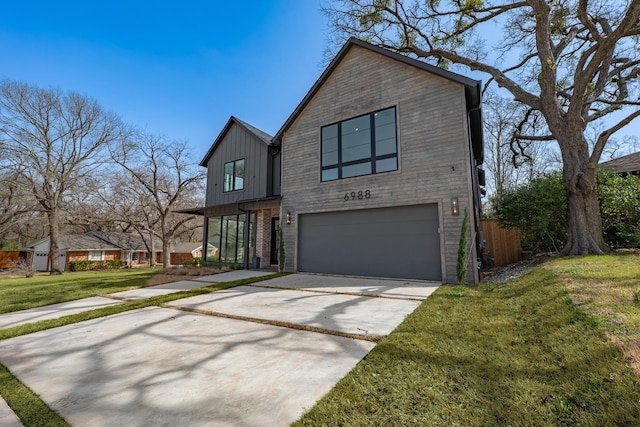 view of front of property with a front yard, board and batten siding, concrete driveway, and an attached garage