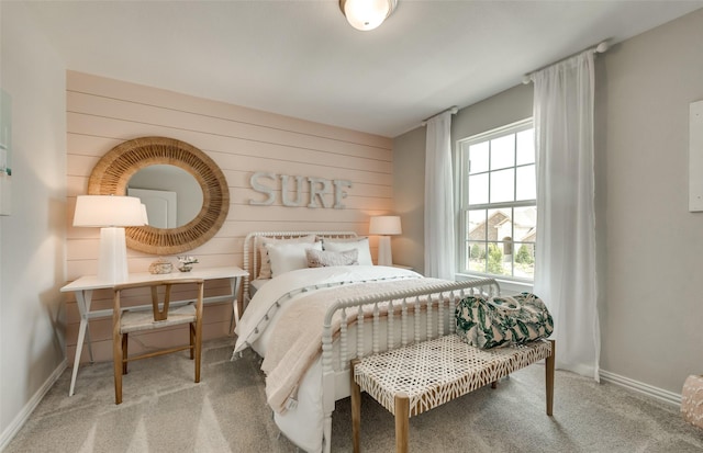 carpeted bedroom with wooden walls and baseboards