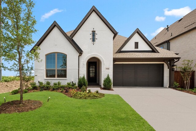 3100 Colt Ln, Celina, TX 75009 - french country home with driveway, roof with shingles, brick siding, and an attached garage