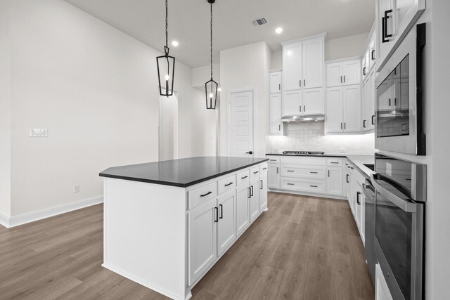 3100 Colt Ln, Celina, TX 75009 - kitchen with light wood finished floors, dark countertops, backsplash, baseboards, and white cabinetry