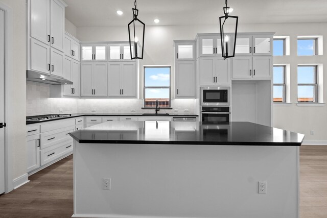 3100 Colt Ln, Celina, TX 75009 - kitchen with under cabinet range hood, dark countertops, built in microwave, oven, and recessed lighting