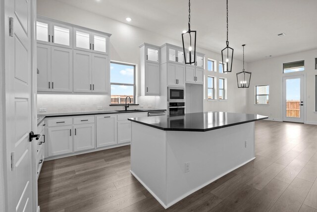 3100 Colt Ln, Celina, TX 75009 - kitchen with a sink, oven, built in microwave, dark wood finished floors, and dark countertops