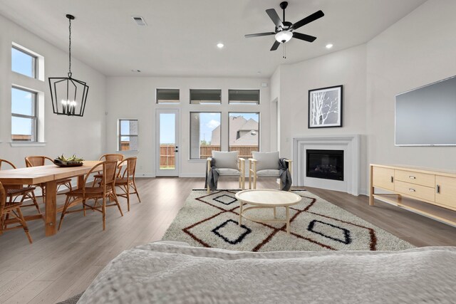 3100 Colt Ln, Celina, TX 75009 - living area with wood finished floors, a chandelier, a glass covered fireplace, recessed lighting, and a ceiling fan
