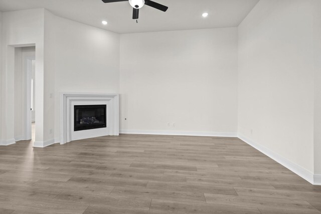 3100 Colt Ln, Celina, TX 75009 - unfurnished living room with ceiling fan, recessed lighting, wood finished floors, baseboards, and a glass covered fireplace