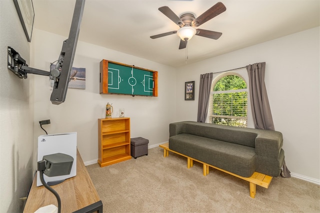 sitting room featuring ceiling fan, baseboards, and carpet