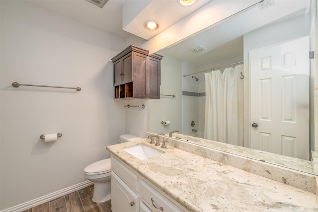 bathroom with visible vents, toilet, wood finished floors, baseboards, and vanity