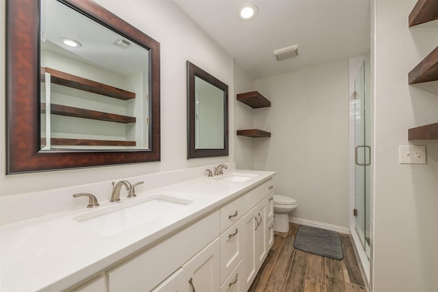 bathroom with toilet, wood finished floors, visible vents, and a sink