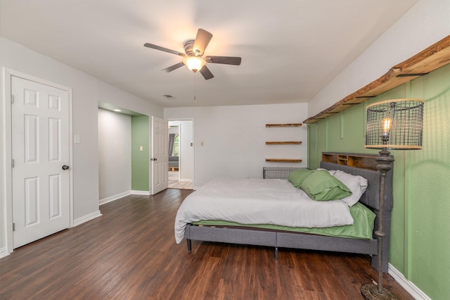 bedroom with ceiling fan, visible vents, baseboards, and wood finished floors