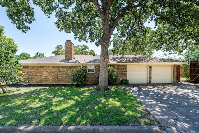 ranch-style house with a chimney, brick siding, driveway, a front lawn, and an attached garage
