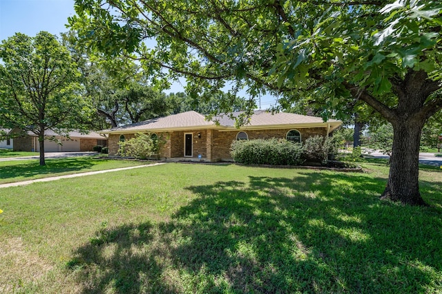 ranch-style house with brick siding, an attached garage, and a front lawn