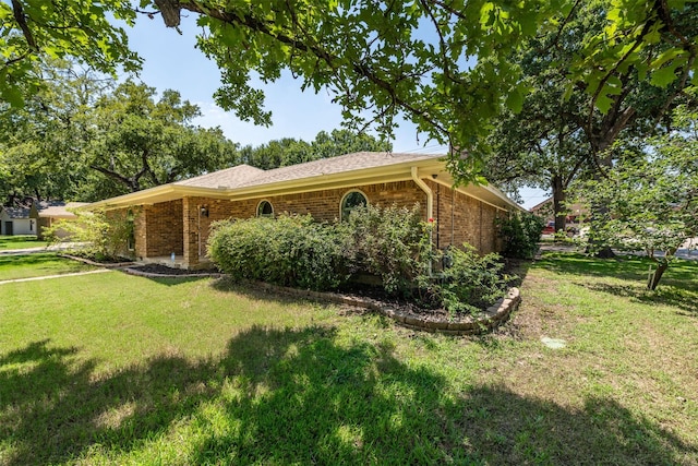 single story home featuring brick siding and a front yard