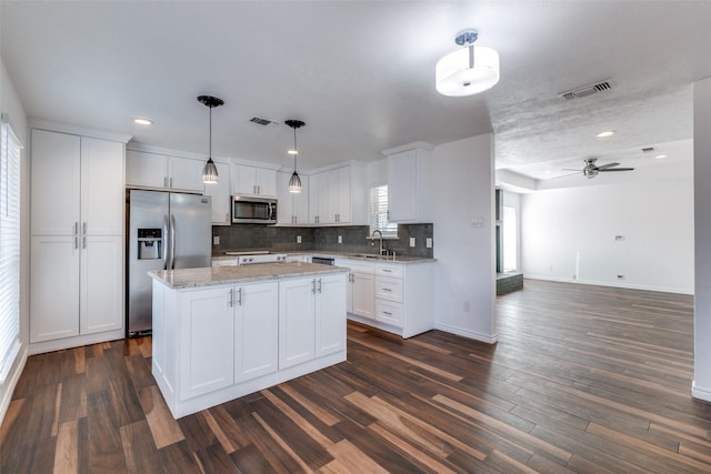 kitchen with dark wood-type flooring, white cabinets, visible vents, and stainless steel appliances