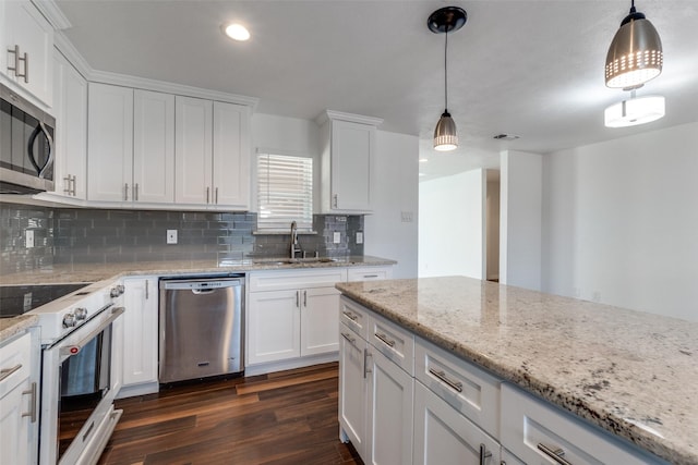 kitchen with dark wood-style floors, a sink, decorative backsplash, appliances with stainless steel finishes, and white cabinetry