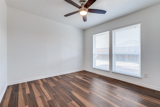 empty room featuring a ceiling fan, dark wood-style floors, and baseboards