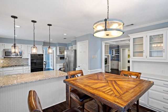 dining area featuring dark wood-type flooring, recessed lighting, visible vents, and ornamental molding