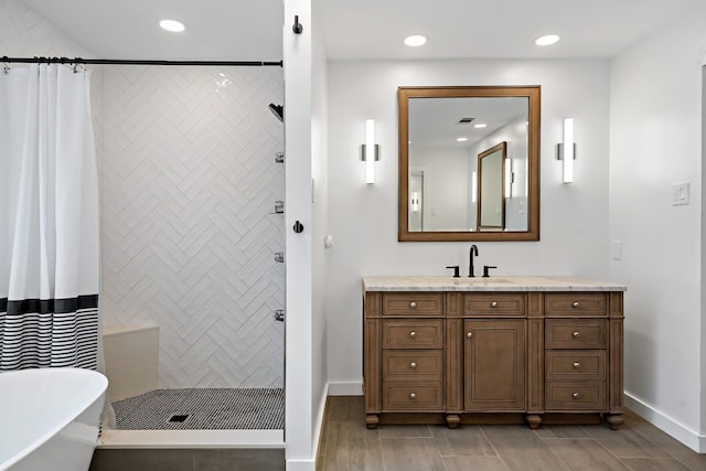 full bathroom with recessed lighting, a freestanding tub, tiled shower, and vanity