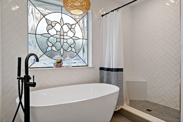 bathroom with a freestanding tub and tiled shower