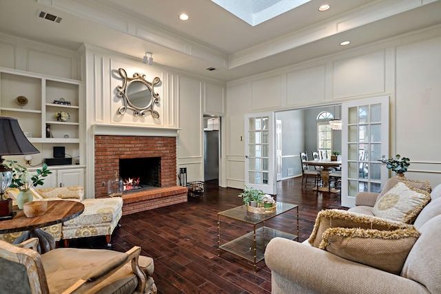 living area featuring a decorative wall, visible vents, and ornamental molding