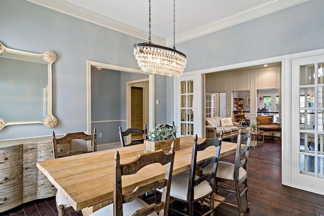 dining room featuring a notable chandelier, dark wood-style floors, and ornamental molding