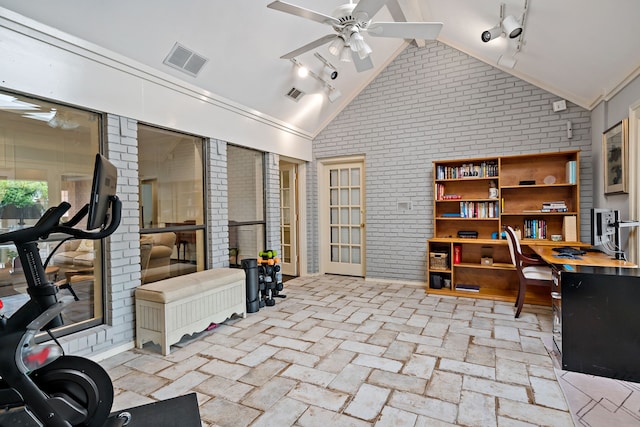 workout area featuring vaulted ceiling, a ceiling fan, visible vents, and brick wall