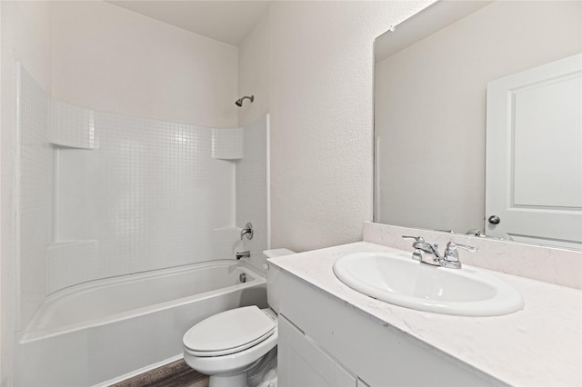 bathroom with toilet, bathtub / shower combination, vanity, and a textured wall