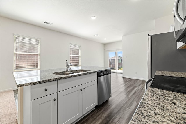 kitchen featuring a sink, stone countertops, dark wood finished floors, appliances with stainless steel finishes, and white cabinets